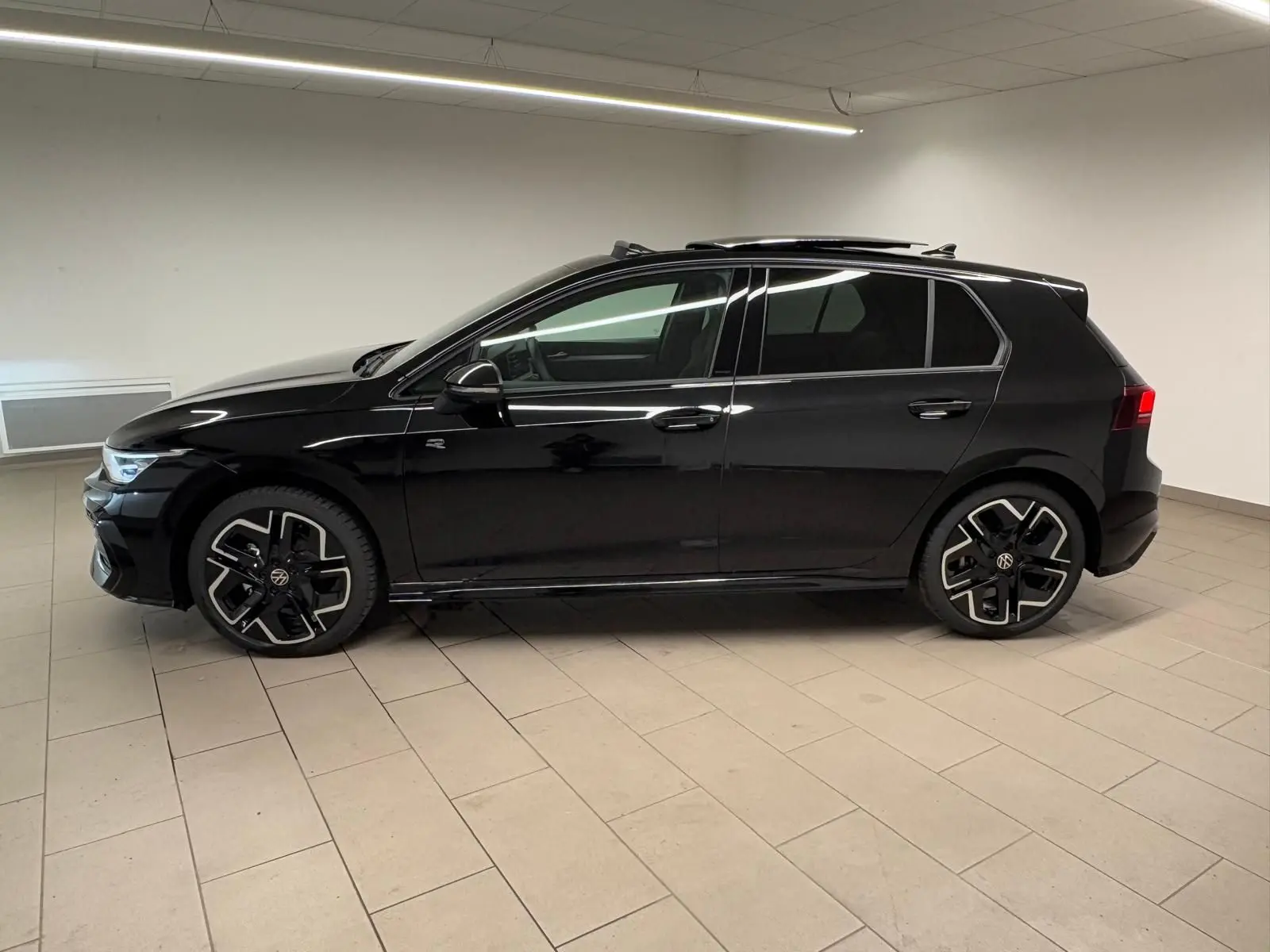 Vue de profil côté gauche d'une Volkswagen Golf 2.0 TDI R-Line noire Grenadille avec toit ouvrant panoramique.