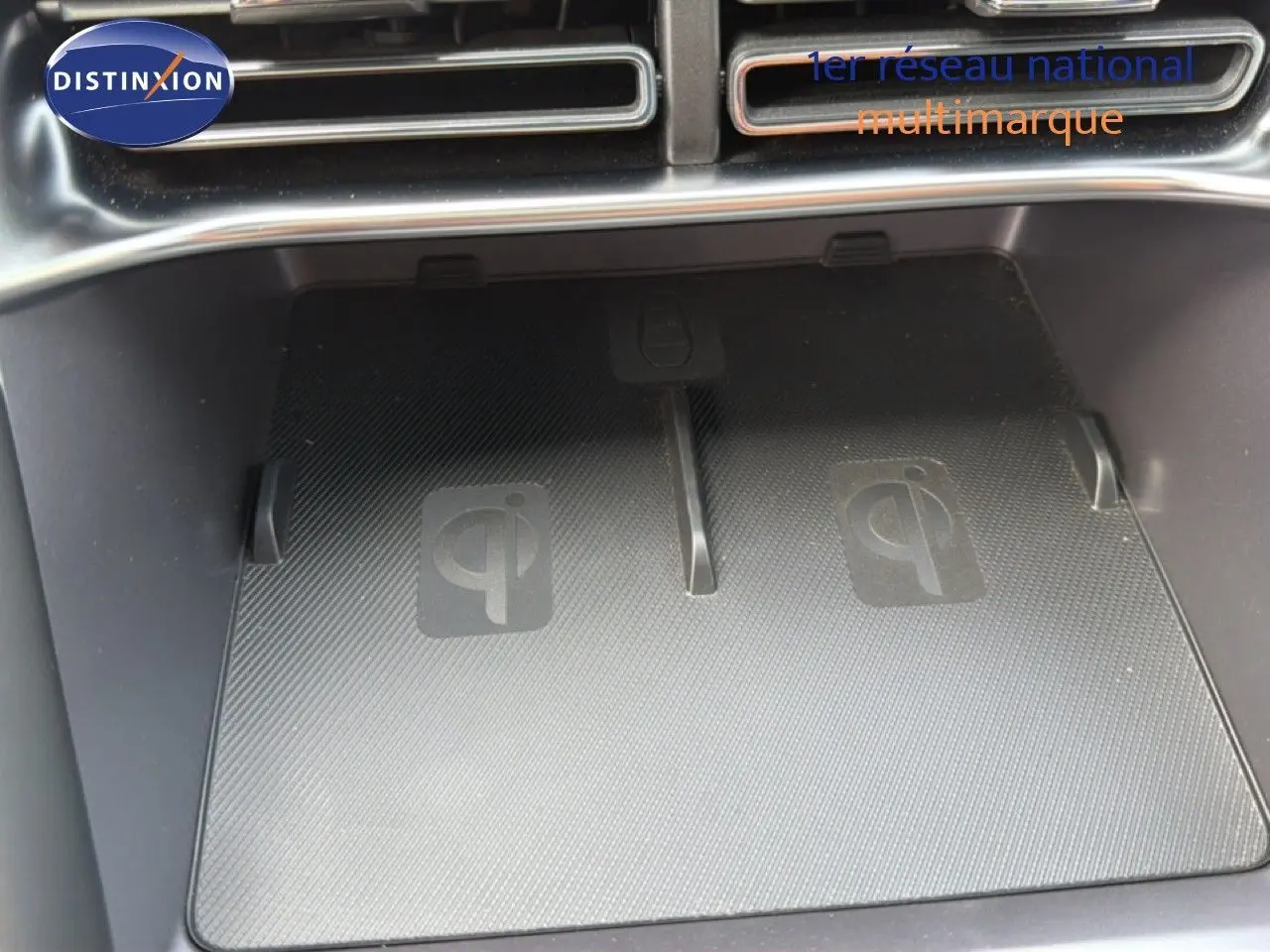 Gros plan sur le chargeur sans fil Qi intégré dans la console centrale du BYD SEAL U hybride rechargeable.