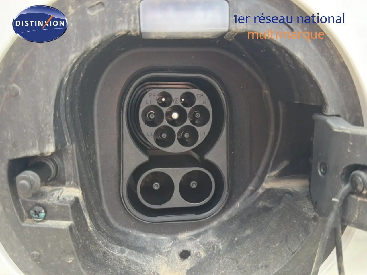 Gros plan sur la prise de recharge hybride du BYD SEAL U Snow White, montrant le connecteur électrique ouvert.