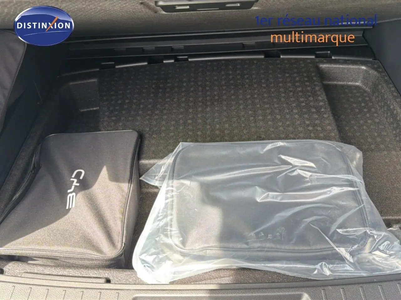 Coffre ouvert d’un BYD SEAL U blanc neige, vue plongeante sur deux sacs de rangement posés à plat.
