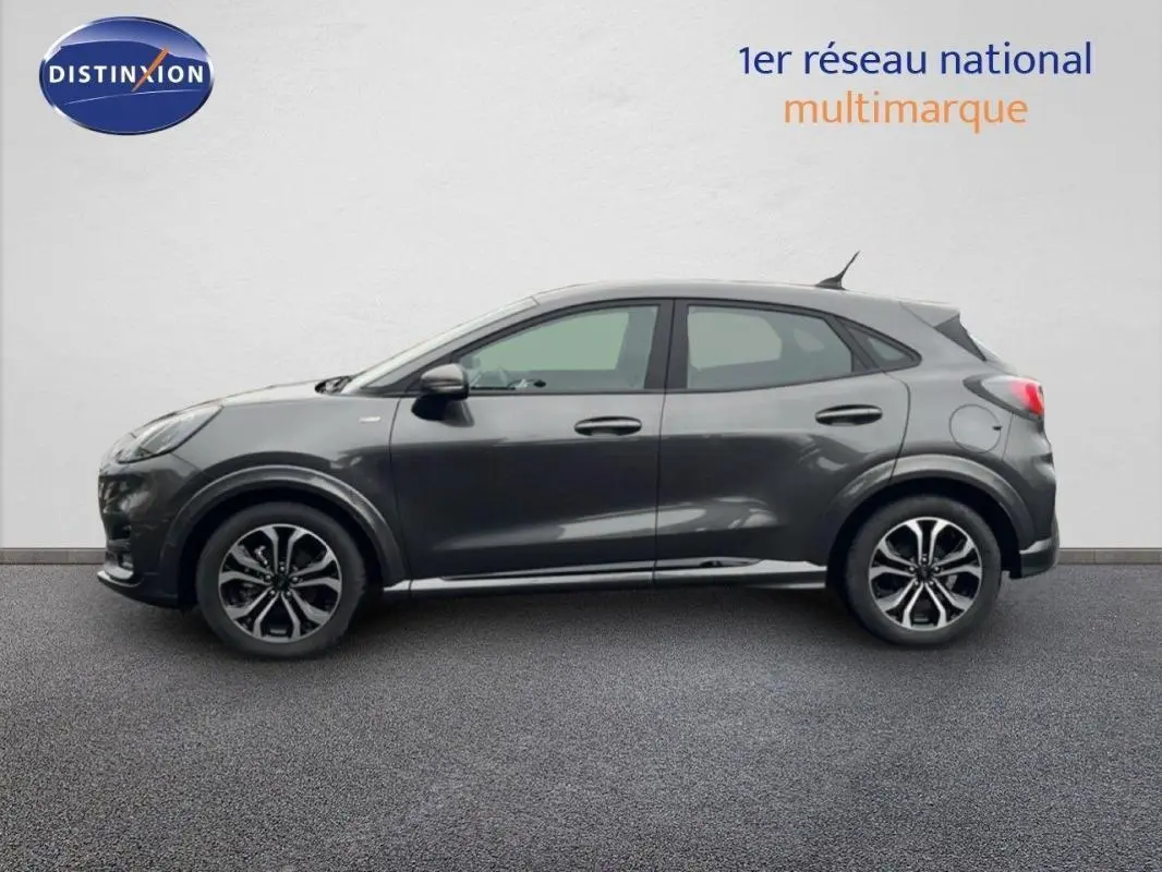 Vue de profil côté gauche d'un Ford Puma gris foncé avec jantes alliage 17 pouces sur fond neutre.