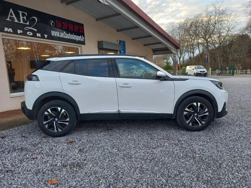 Peugeot 2008 blanc vue de profil côté gauche, avec jantes alliage et toit noir contrastant.