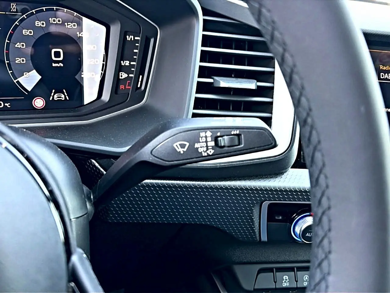 Vue rapprochée du tableau de bord et volant cuir noir de l'Audi A1 Sportback 2026 avec écran numérique et commandes au volant.