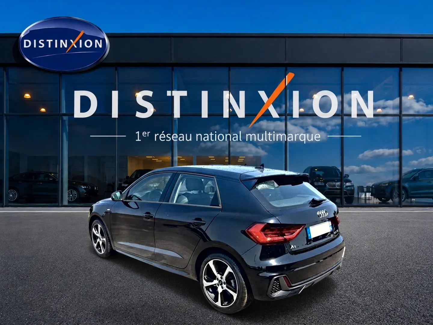 Audi A1 Sportback noir vue 3/4 arrière droit, avec jantes alliage et becquet arrière distinctif.