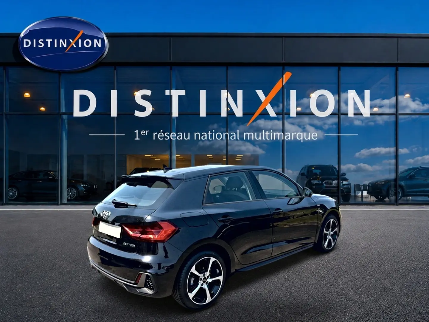 Audi A1 Sportback noir vue 3/4 arrière droit avec jantes alliage et becquet arrière, devant showroom Distinxion.