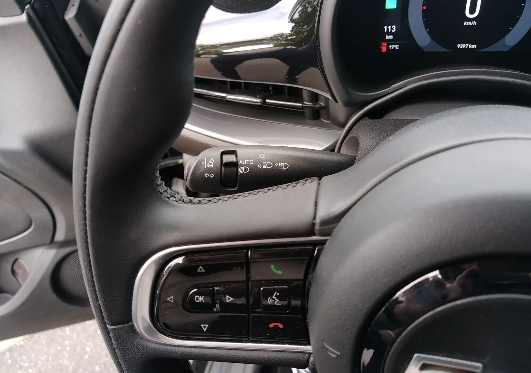 Gros plan sur le volant noir et le combiné d'instruments digital de la Fiat 500 électrique 2024, côté gauche.