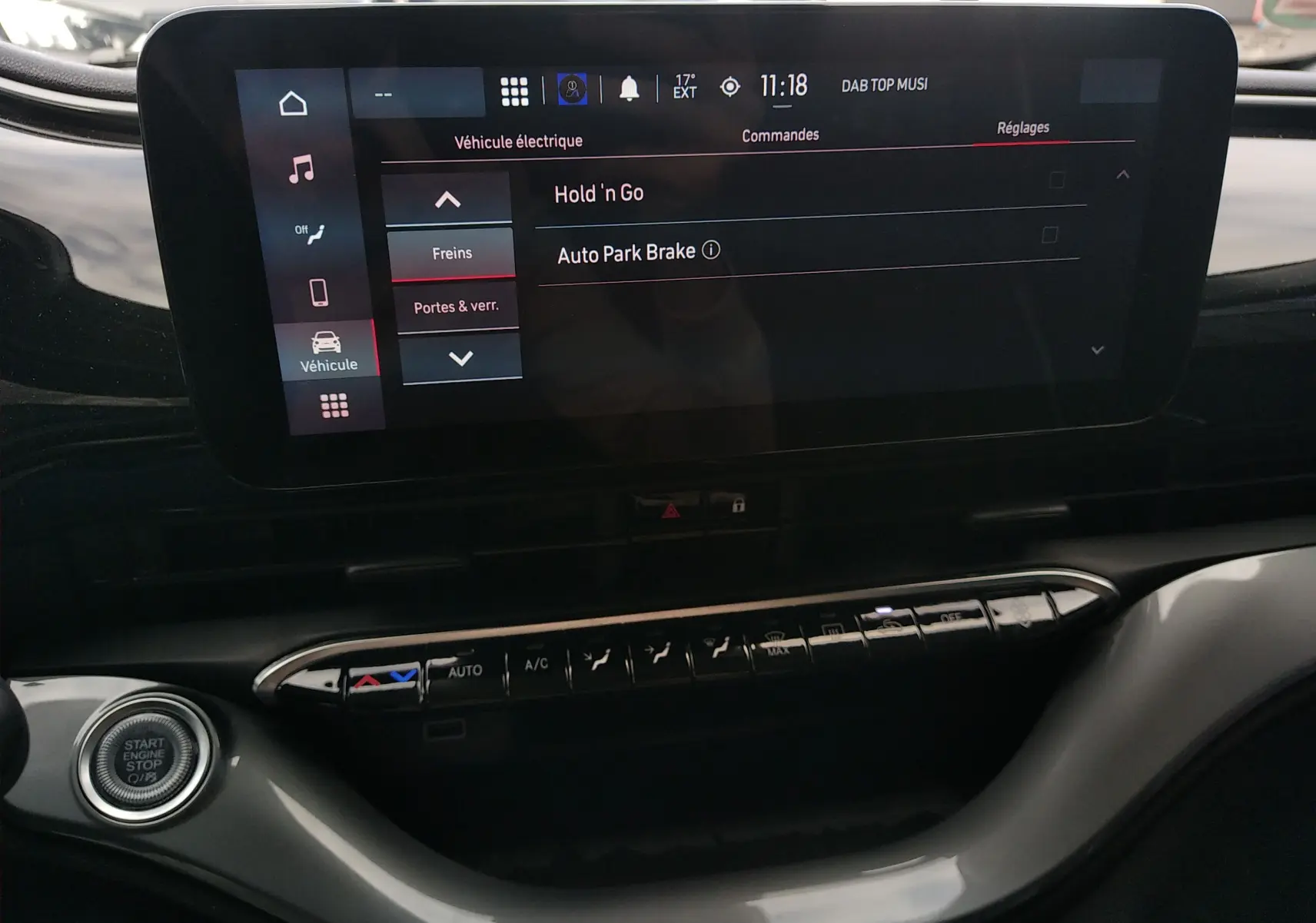 Écran tactile central de la Fiat 500 électrique 2024, vue intérieure du tableau de bord avec commandes climatisation et bouton start/stop.