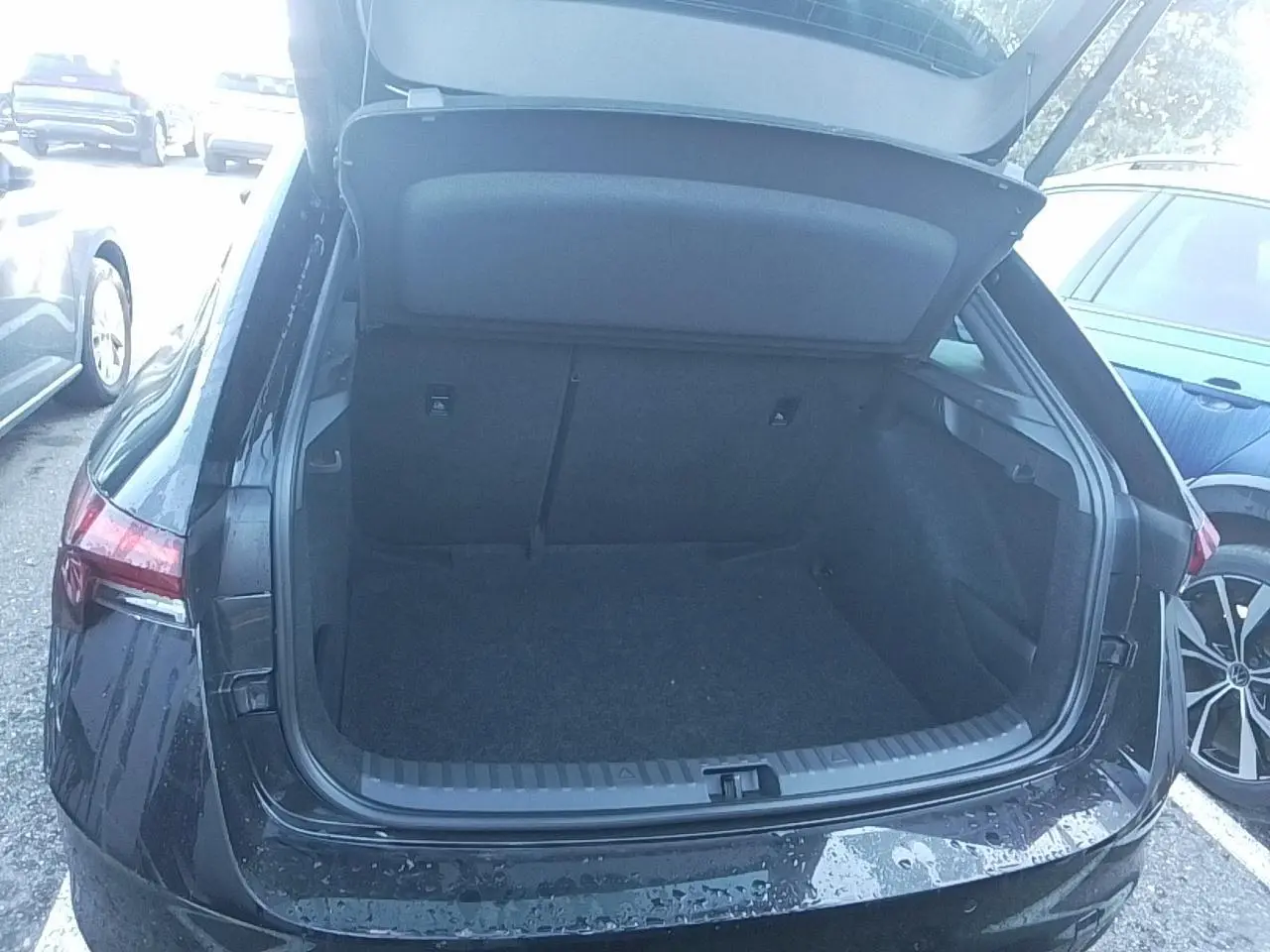 Vue arrière du coffre ouvert d'une Skoda Scala TSI 116 DSG7 Monte-Carlo en noir Magic, avec hayon électrique.
