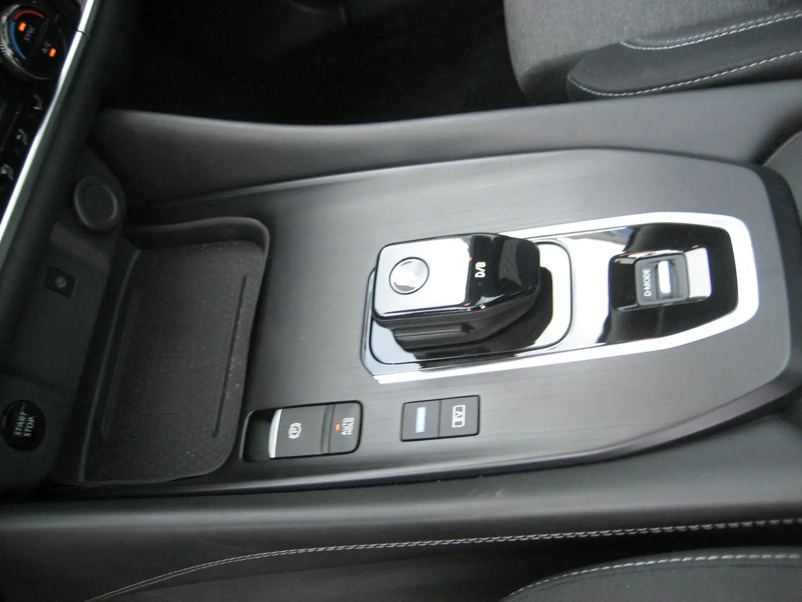 Vue rapprochée de la console centrale noire du Nissan Qashqai 2024 avec levier de vitesse automatique et boutons de commande.