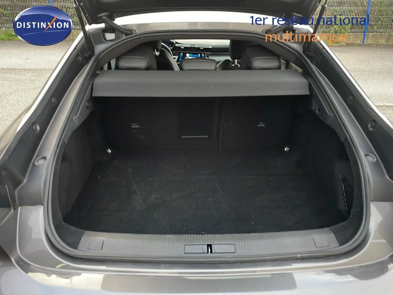 Coffre ouvert vu de l'arrière d'une Peugeot 508 gris platinium métal, montrant l'espace de chargement vide.