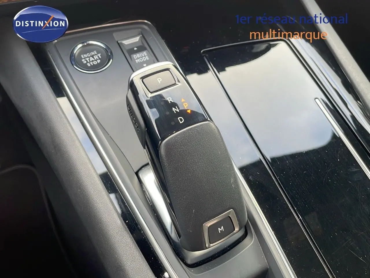 Vue rapprochée du levier de vitesse automatique de la Peugeot 508 gris platinium métal, avec bouton start/stop et drive mode.