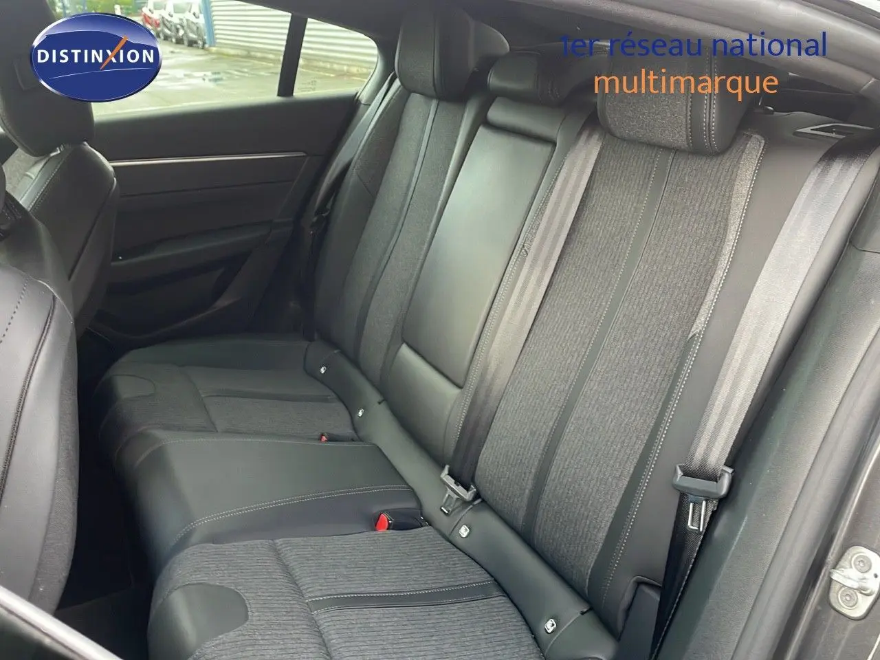 Vue intérieure montrant la banquette arrière en cuir et tissu gris d’une Peugeot 508 2023, porte arrière ouverte.