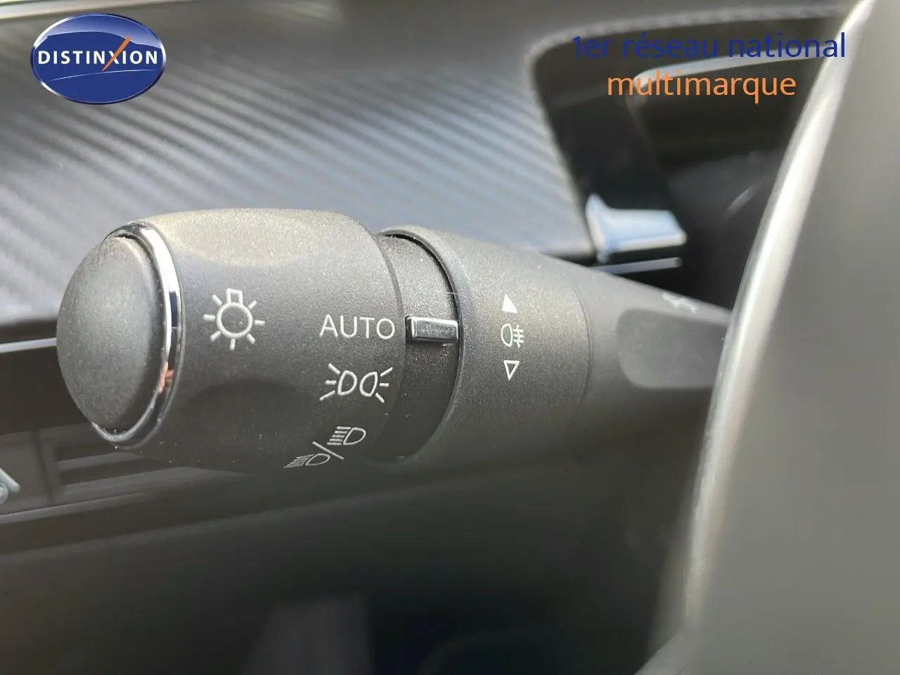 Gros plan sur la commande des phares automatique à gauche du volant dans une Peugeot 508 gris platinium 2023.