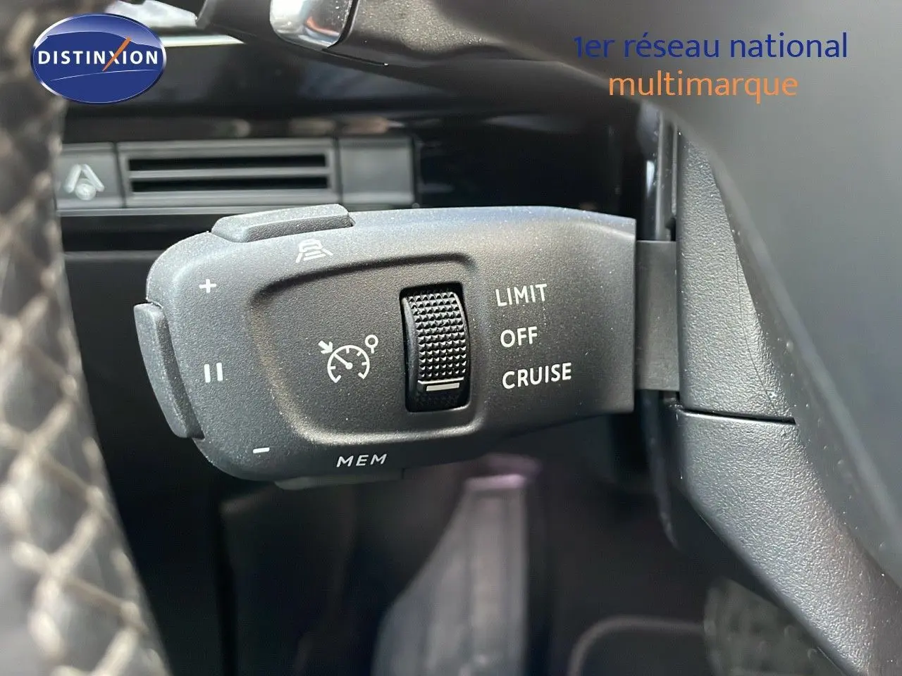 Gros plan sur la commande de régulateur de vitesse au volant d'une Peugeot 508 gris platinium, intérieur noir.