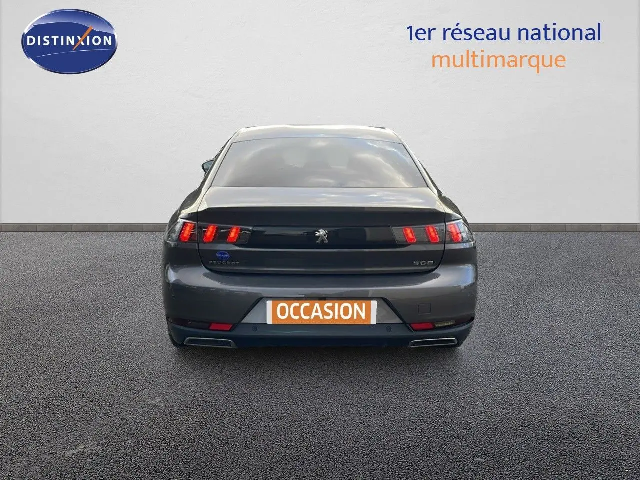 Vue arrière d'une Peugeot 508 gris platinium métal 2023 avec feux LED distinctifs et double sortie d'échappement.
