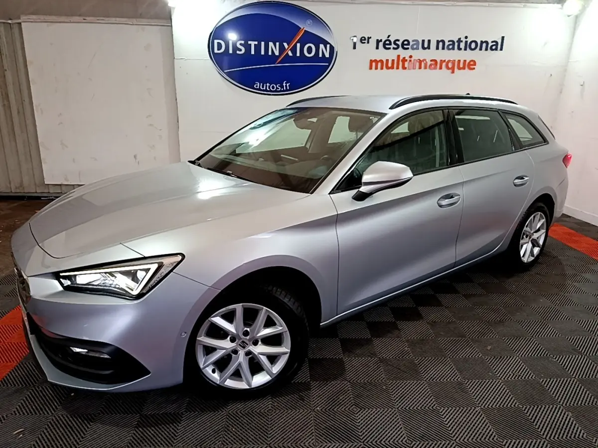 Vue 3/4 avant droit d'une SEAT LEON gris clair 2022 en break, avec feux LED et jantes alliage visibles.