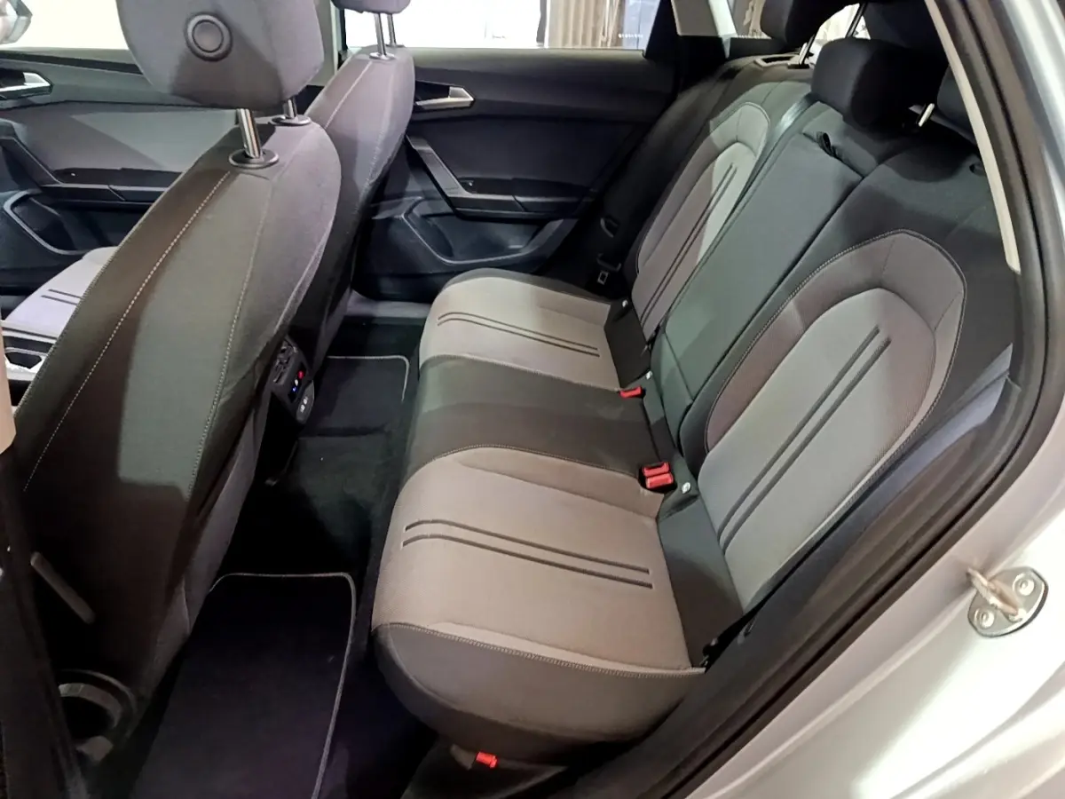 Vue côté droit de l'habitacle arrière gris clair du SEAT LEON 2.0 TDI 150 DSG avec sièges tissu bicolores.
