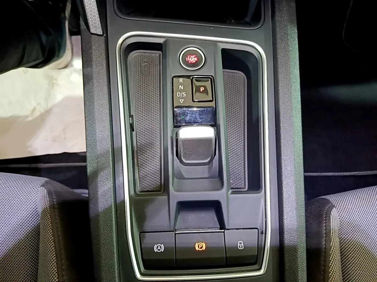 Vue plongeante sur la console centrale grise du SEAT Leon 2022 avec levier de boîte auto et bouton start/stop rouge.