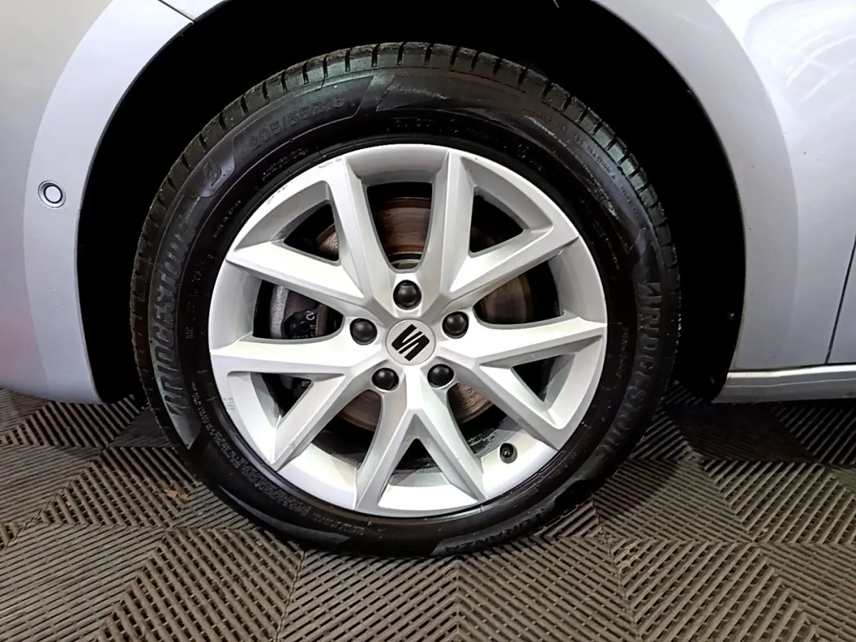 Gros plan sur la roue avant gauche gris clair de la SEAT LEON 2.0 TDI 150 DSG avec jante alliage à 10 branches.