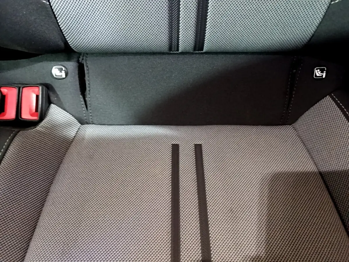 Gros plan sur la banquette arrière grise du SEAT LEON 2022 avec logos Isofix et boucles de ceinture rouges visibles.
