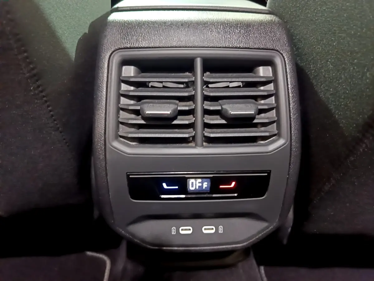 Gros plan sur la console arrière noire du SEAT LEON gris clair 2022 avec commandes climatisation et ports USB visibles