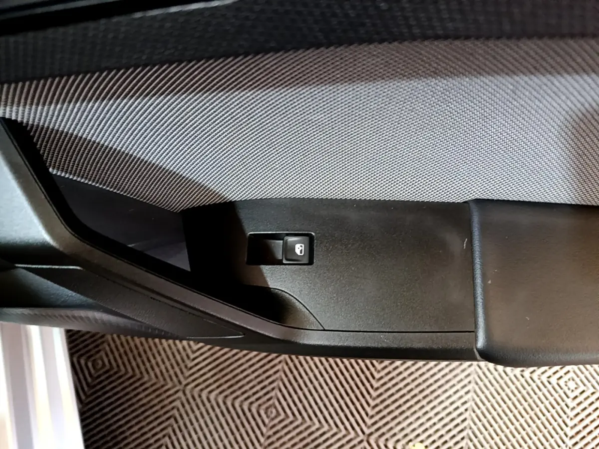 Détail de la commande de verrouillage sur la portière côté conducteur d'une SEAT LEON gris clair 2022.