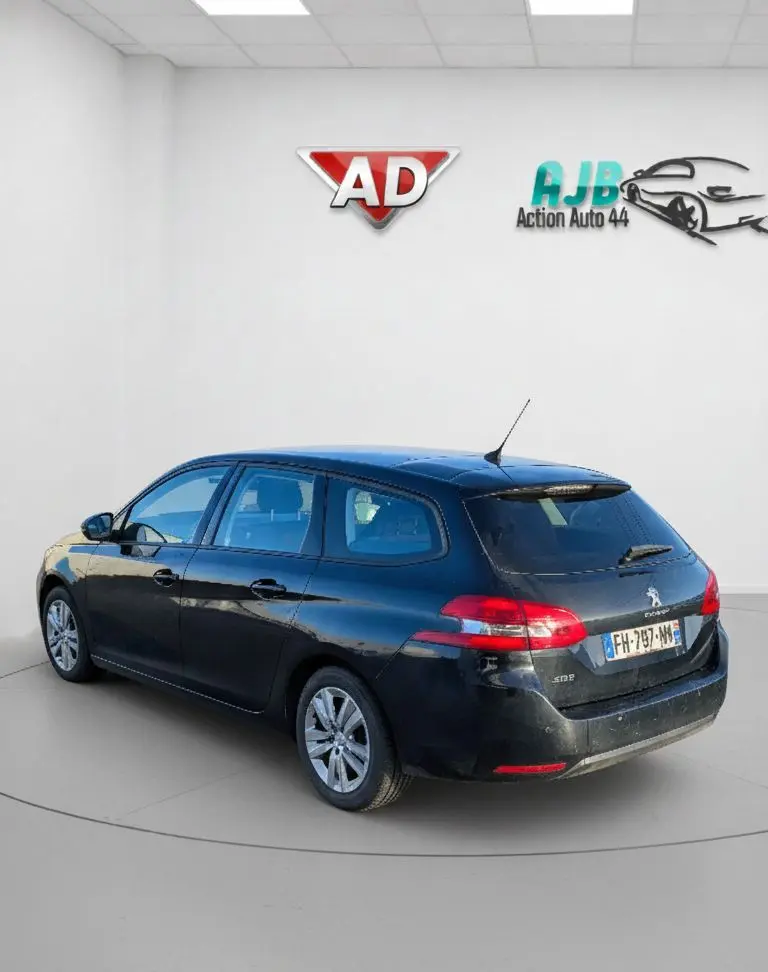 Peugeot 308 SW noire vue en 3/4 arrière droit, avec feux arrière LED et jantes alliage visibles.