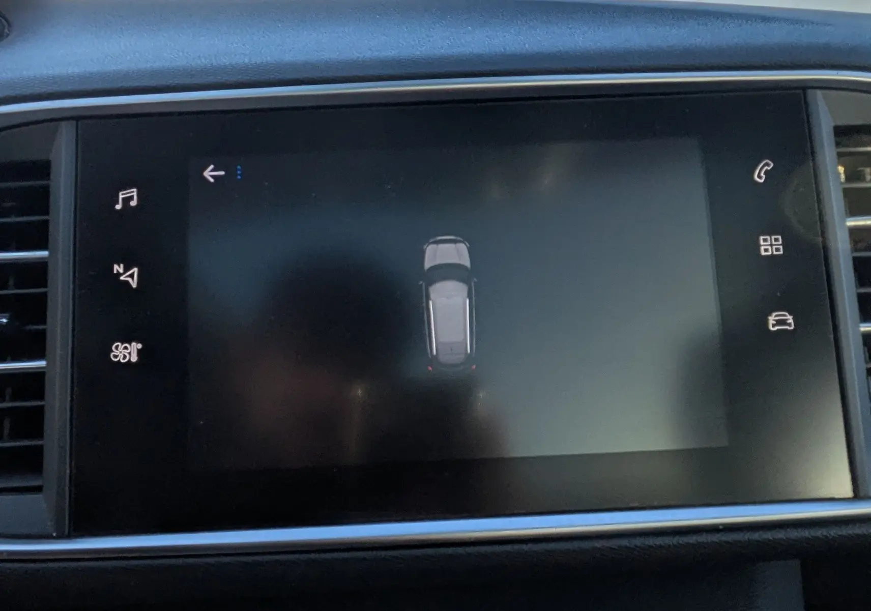 Vue rapprochée de l'écran tactile central noir affichant le système de guidage de stationnement de la Peugeot 308 SW.