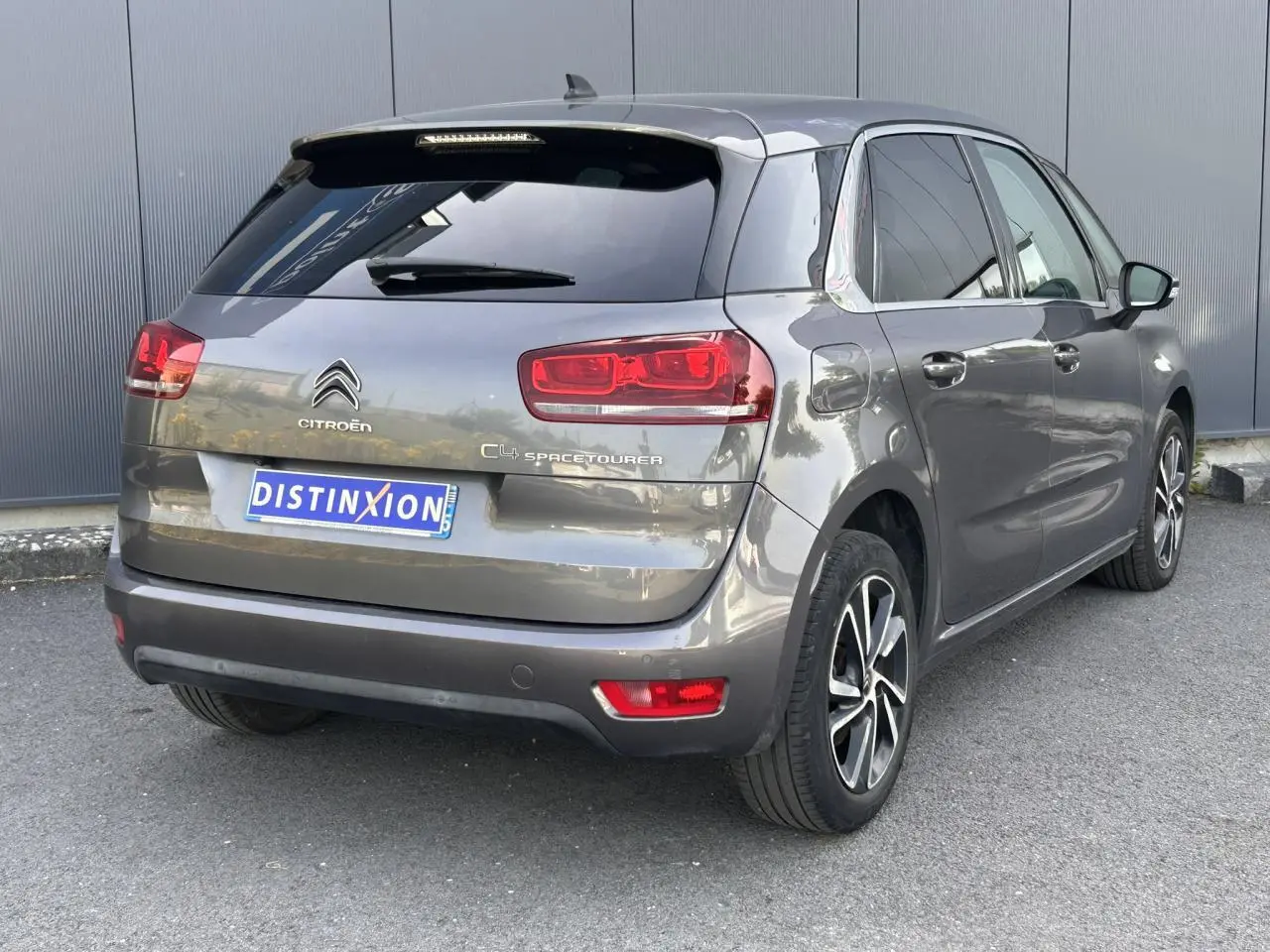 Vue 3/4 arrière droit d'une Citroën C4 Spacetourer gris Platinium avec jantes alliage bi-ton et vitres surteintées.