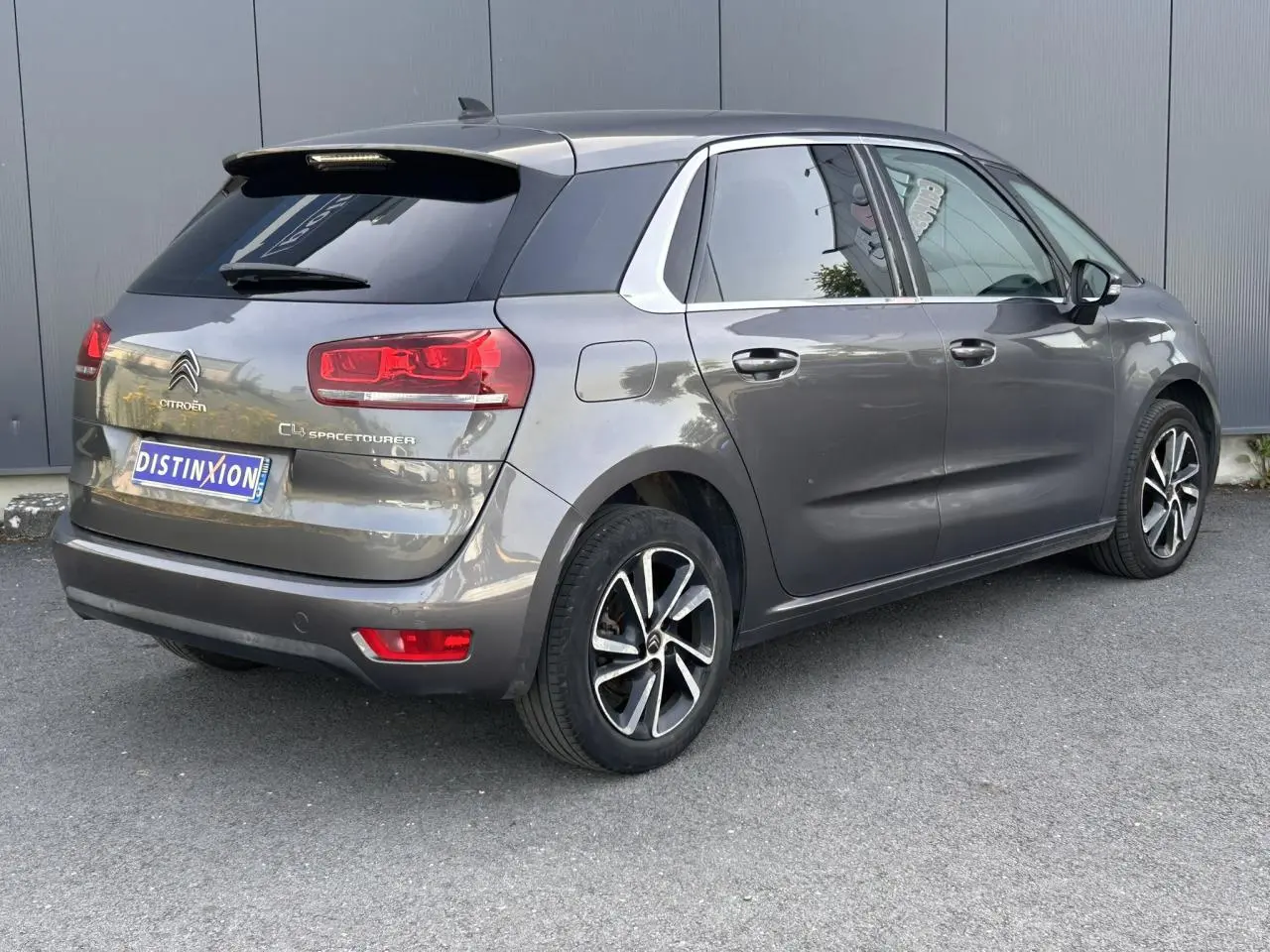 Vue 3/4 arrière droit d'une Citroën C4 Spacetourer gris Platinium avec jantes alliage bi-ton et vitres surteintées.