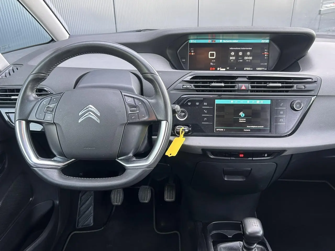 Vue frontale de l'intérieur du Citroën C4 Spacetourer 2019, tableau de bord avec écran tactile et volant multifonctions.