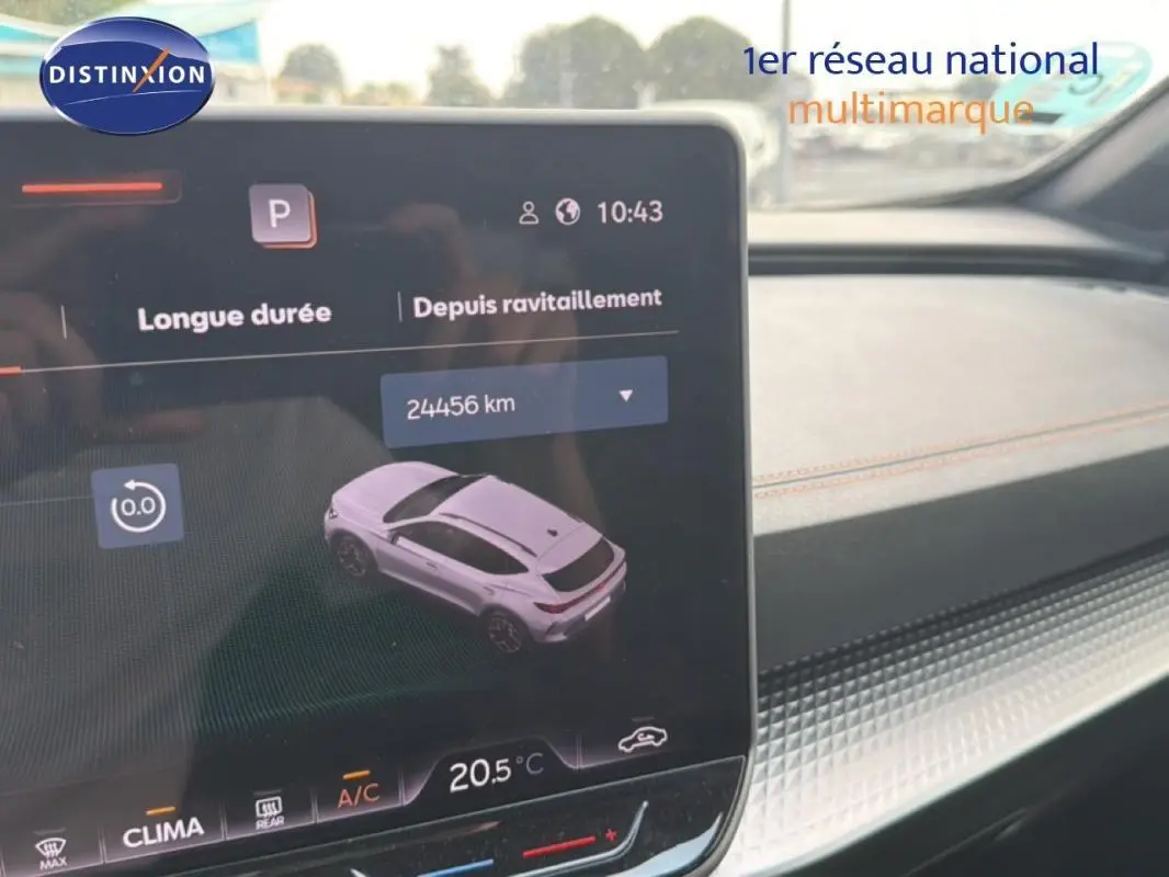 Vue intérieure sur l'écran tactile du tableau de bord montrant une voiture grise foncée en 3/4 arrière.