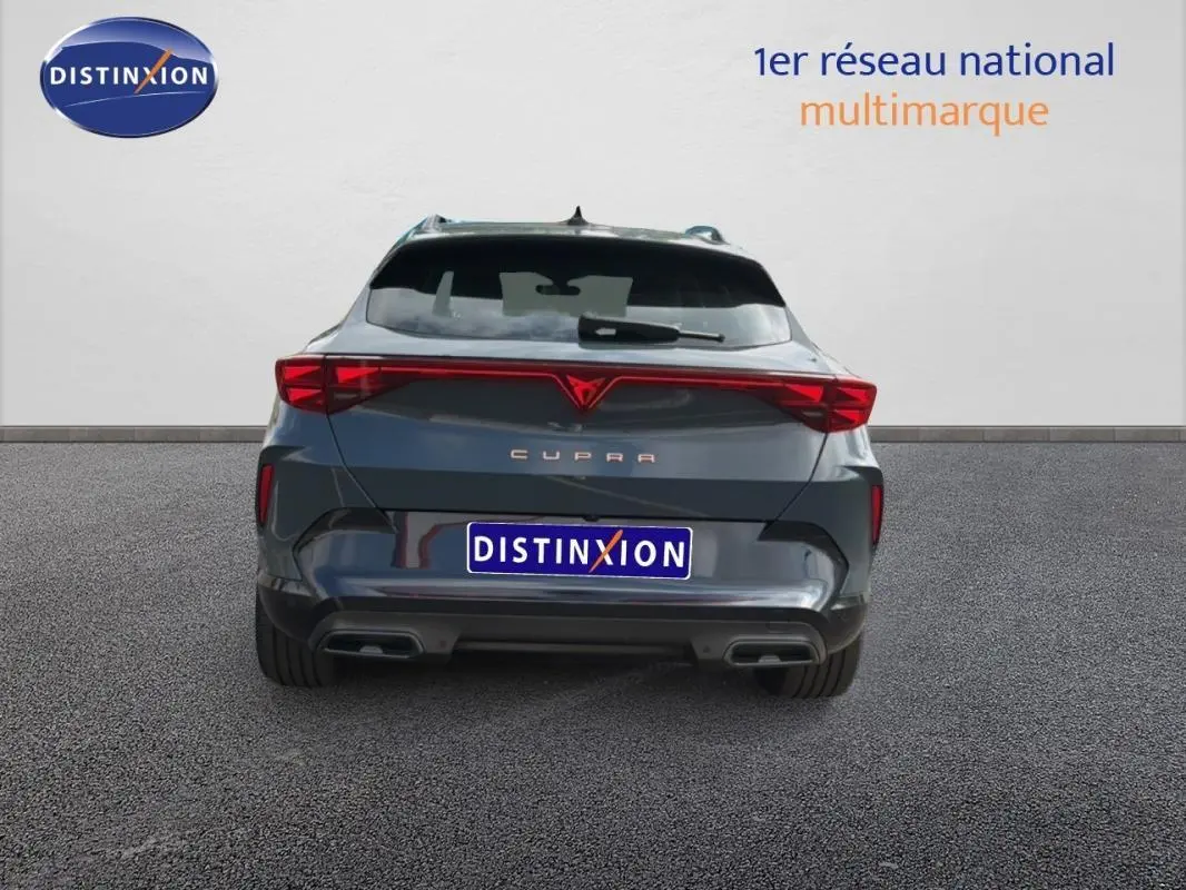 Vue arrière d'un CUPRA Formentor gris foncé 2025 avec feux LED reliés et double sortie d'échappement intégrée.