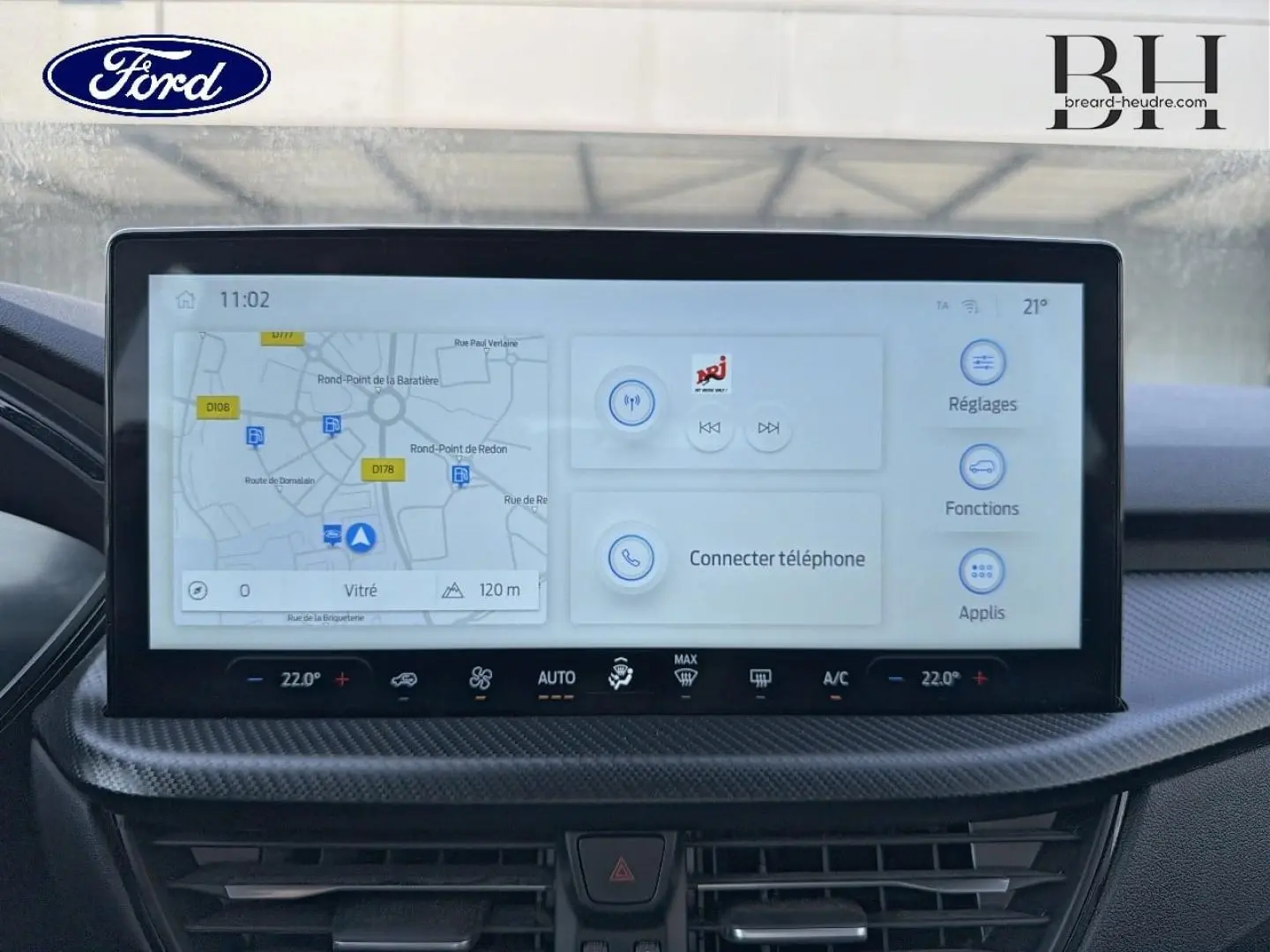 Écran tactile central du Ford Kuga 2025 affichant GPS et options multimédia, avec bordure noire et finition carbone.