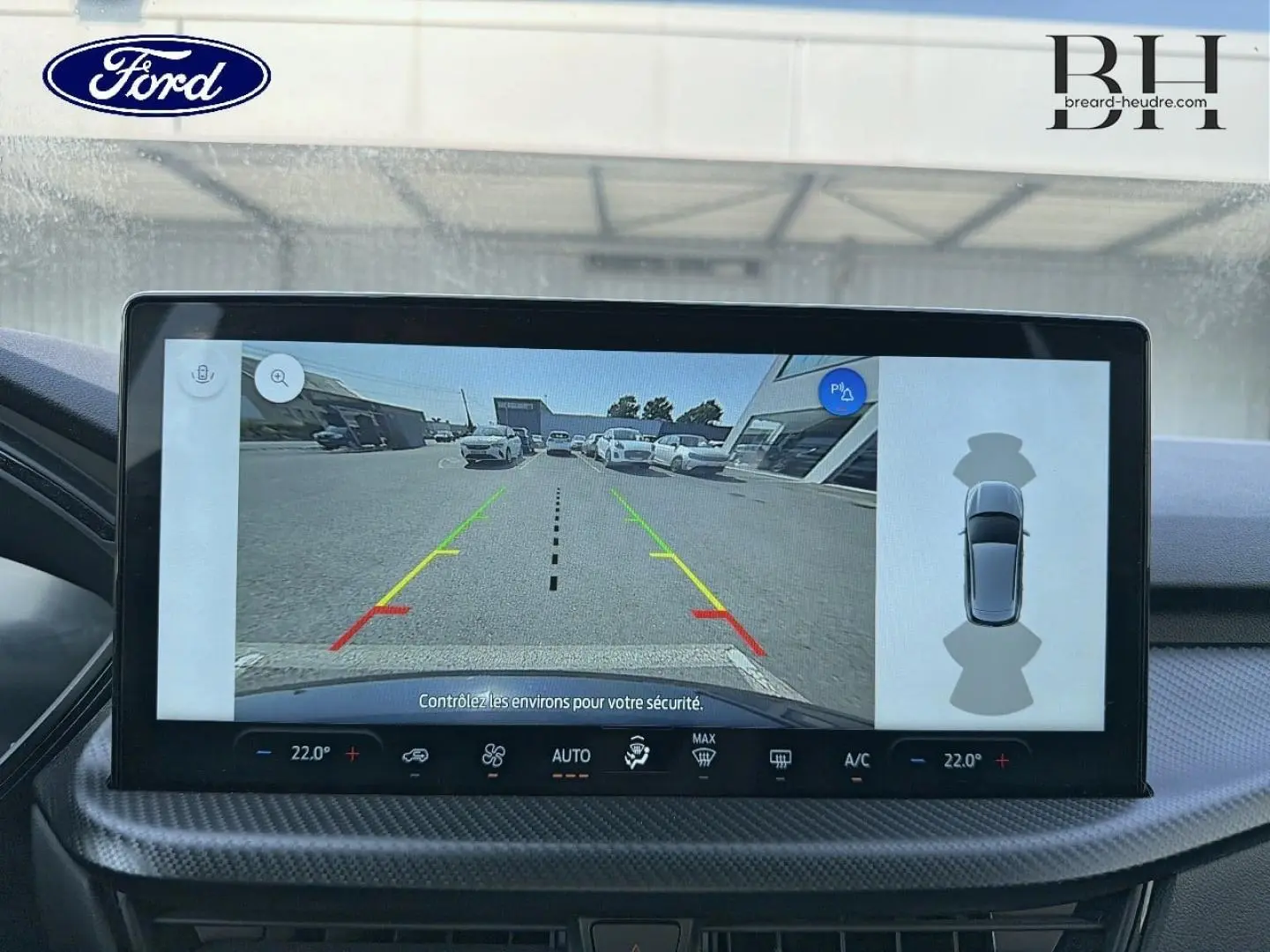 Écran tactile intérieur du Ford Kuga 2025 montrant la caméra de recul et l'affichage du stationnement assisté.