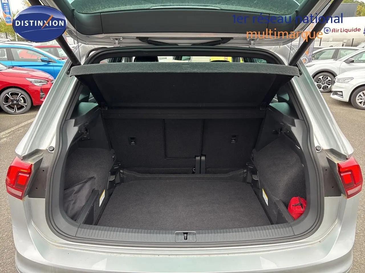 Coffre ouvert vue arrière d’un Volkswagen Tiguan 2024 Reflex Silver Metal, montrant un espace de chargement spacieux et propre.