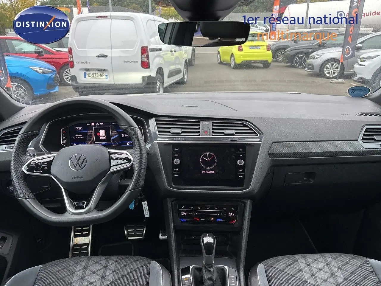 Vue intérieure frontale du Volkswagen Tiguan 1.5 TSI 150CH R-Line 2024, tableau de bord gris noir avec volant multifonction et écran tactile central.