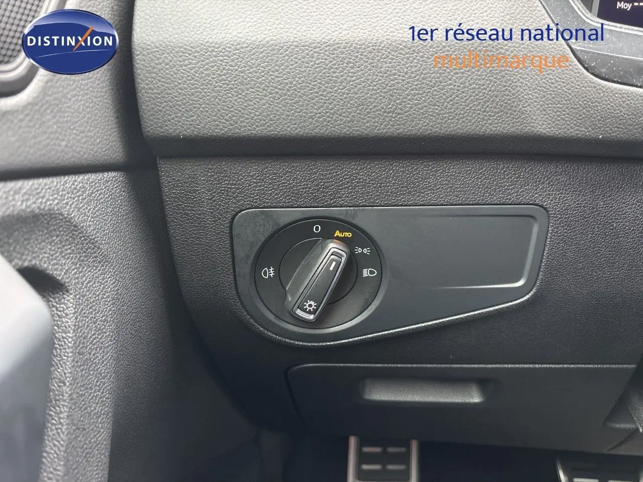 Gros plan sur le sélecteur de phares en position auto dans l’habitacle noir du Volkswagen Tiguan 2024 Reflex Silver.
