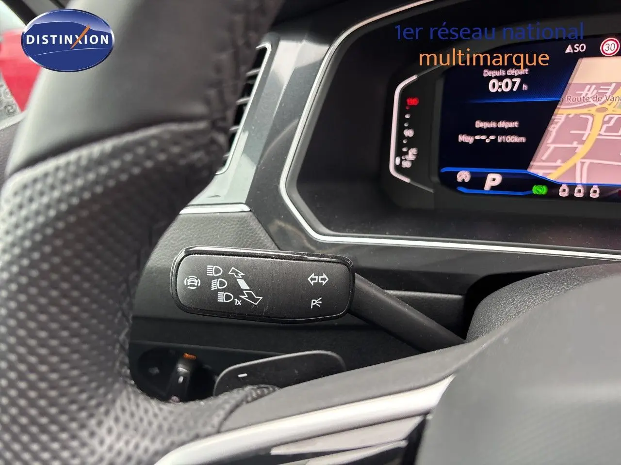 Gros plan sur le commodo gauche et le tableau de bord numérique du Volkswagen Tiguan 2024 en intérieur gris noir.