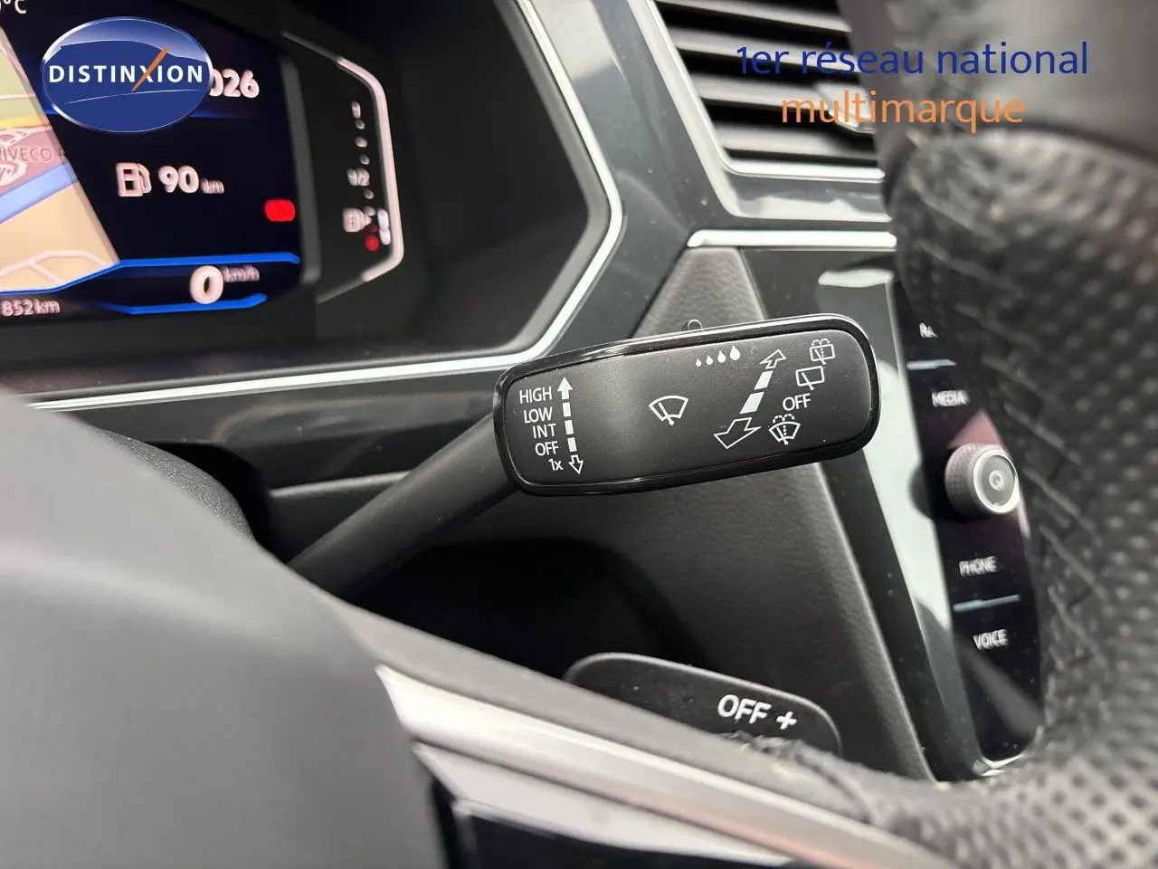 Gros plan sur la commande d’essuie-glace à gauche du volant dans l’habitacle gris noir du Volkswagen Tiguan 2024.