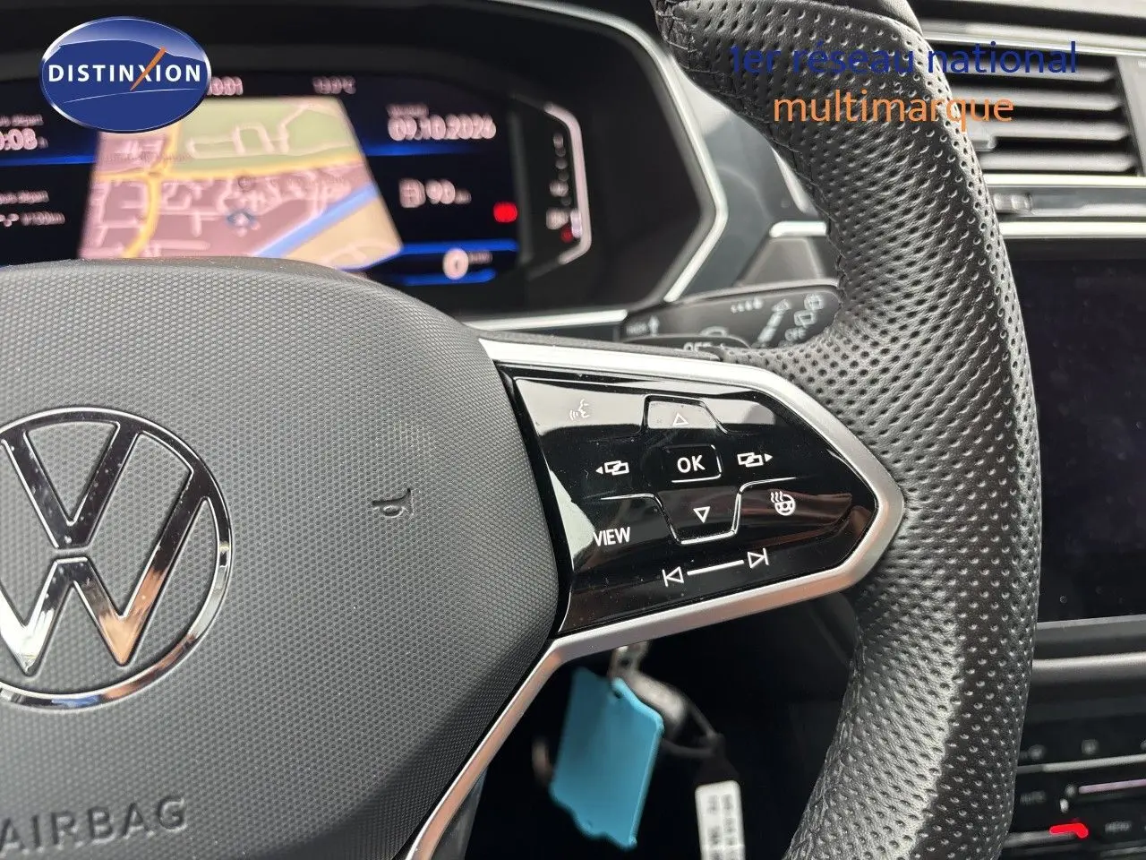 Gros plan sur le volant perforé et les commandes multifonctions d’un Volkswagen Tiguan 2024 couleur Reflex Silver Metal.