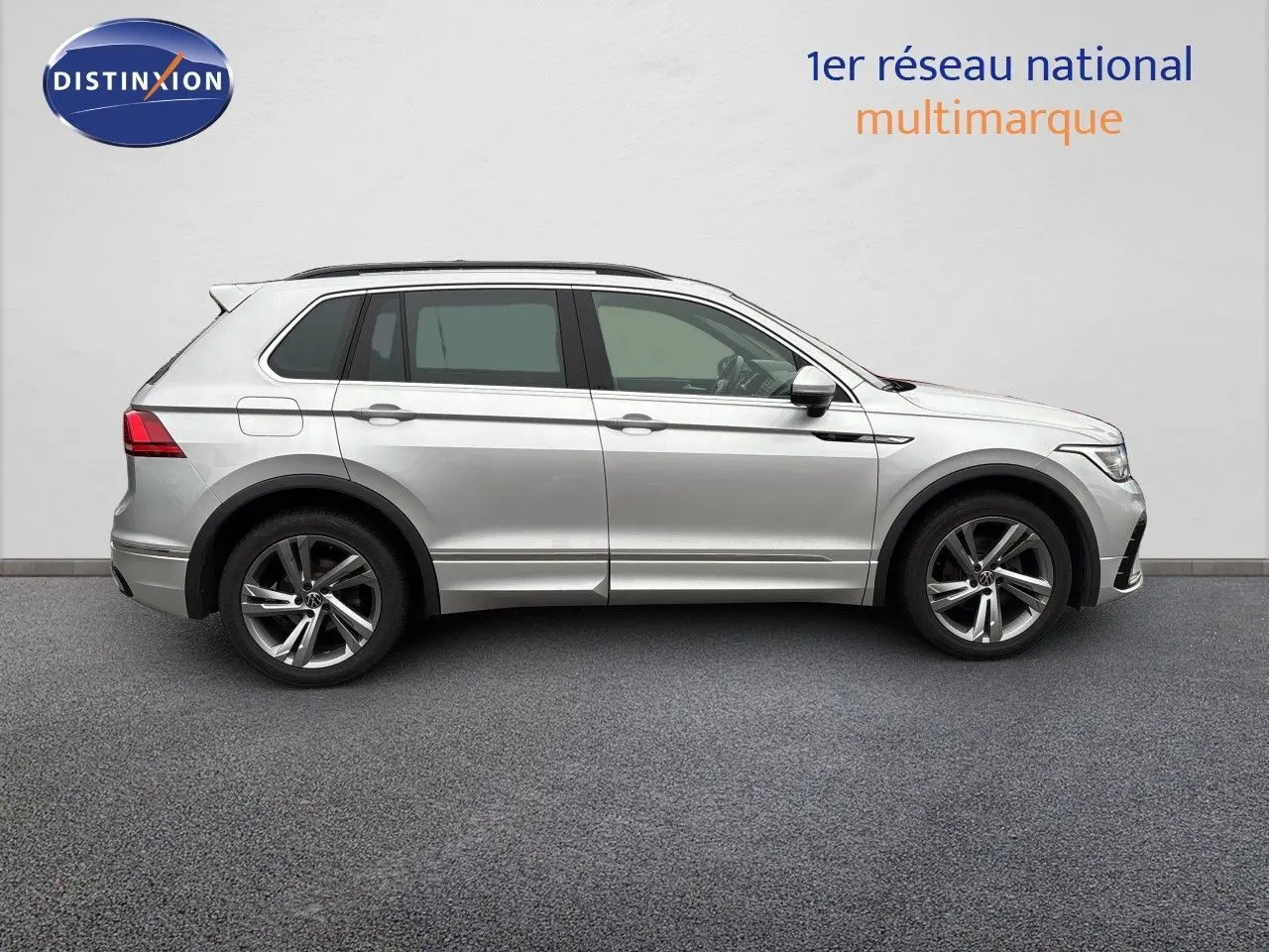 Profil droit d'un Volkswagen Tiguan 1.5 TSI R-Line 2024 en Reflex Silver Metal avec jantes alliage et détails noirs.