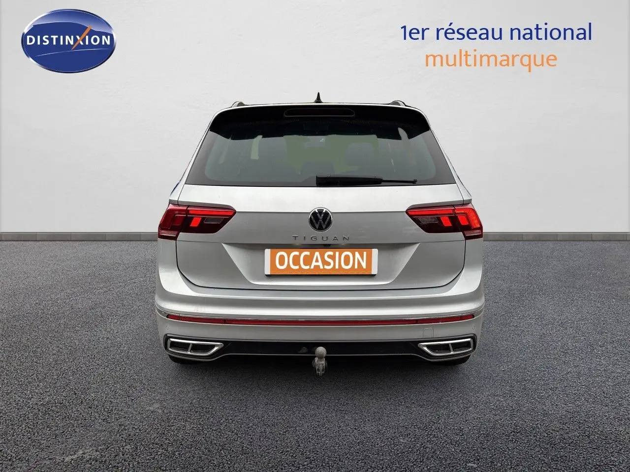 Vue arrière d'un Volkswagen Tiguan 1.5 TSI R-Line 2024 en Reflex Silver Metal avec attelage visible.