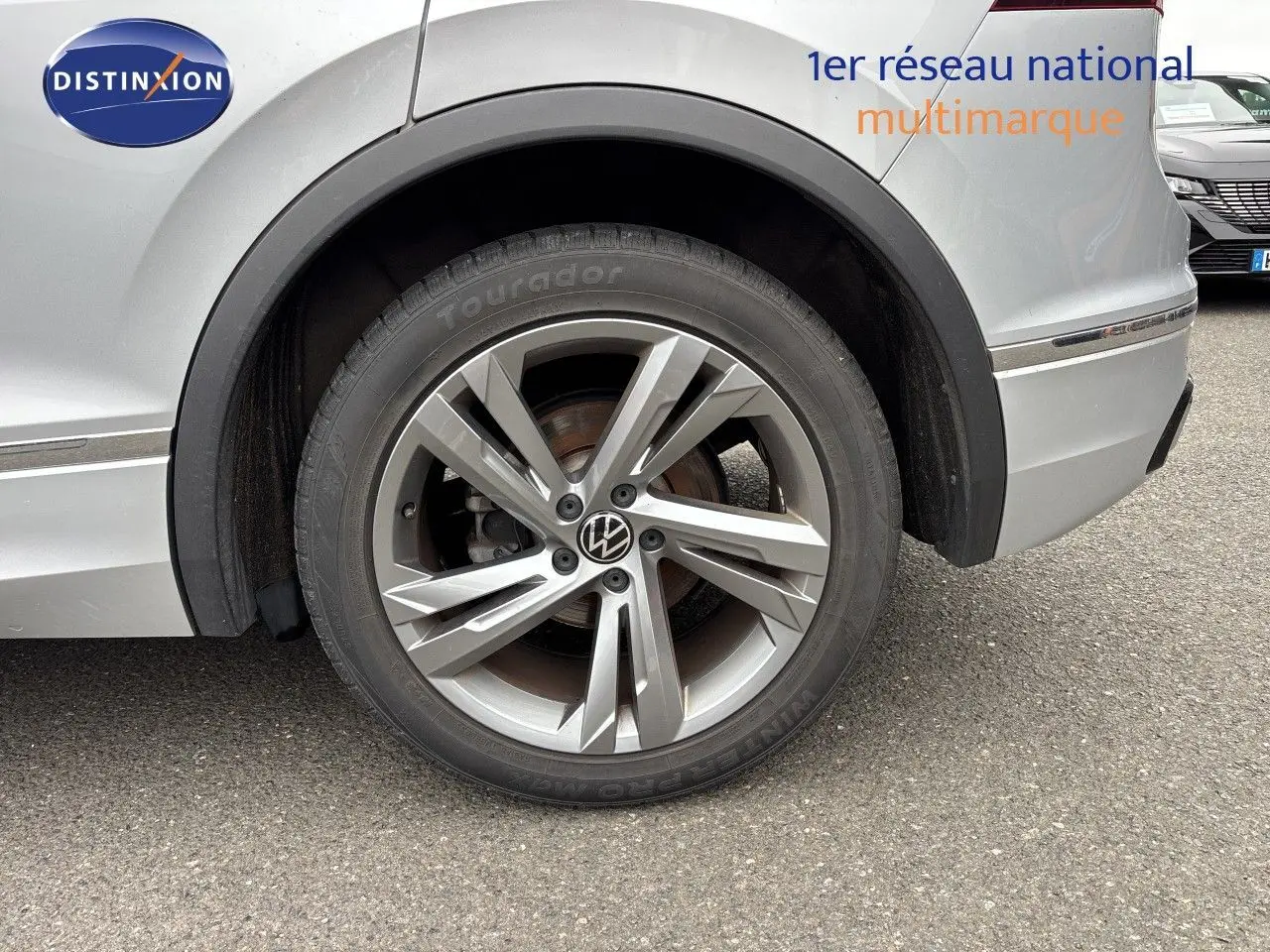 Gros plan sur la roue arrière droite d’un Volkswagen Tiguan 2024 Reflex Silver avec jante alliage R-Line.