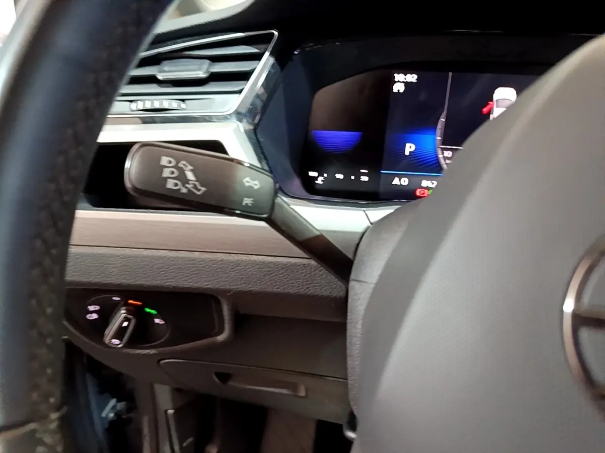 Gros plan intérieur sur le tableau de bord et levier de commande de la Volkswagen Touran 2.0 TDI gris foncé, affichage digital visible.