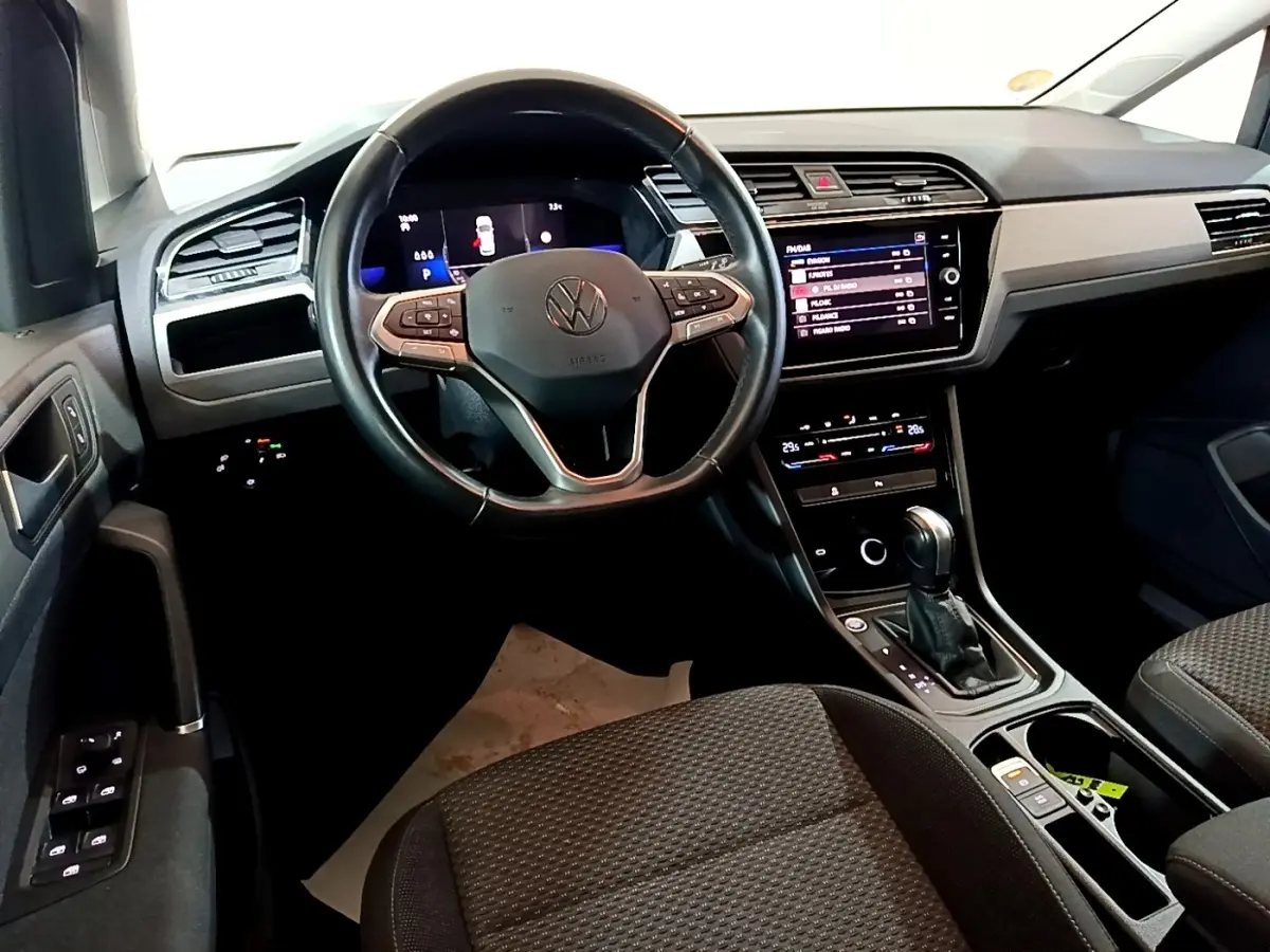 Intérieur du Volkswagen Touran 2023 vu du siège conducteur, avec tableau de bord numérique et console centrale moderne.
