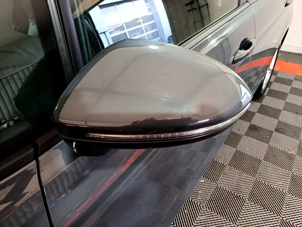 Rétroviseur droit gris foncé du Volkswagen Touran 2023, vue rapprochée sur la portière et la poignée.