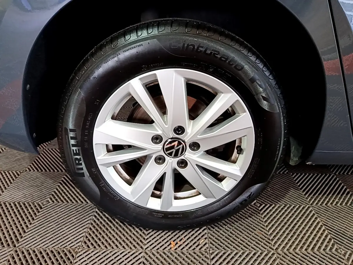 Gros plan sur la roue avant droite d'un Volkswagen Touran gris foncé avec jante alliage et pneu Pirelli.