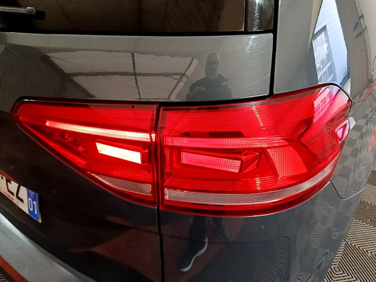 Feu arrière droit rouge sur Volkswagen Touran gris foncé 2023, vue rapprochée du coin arrière du véhicule.