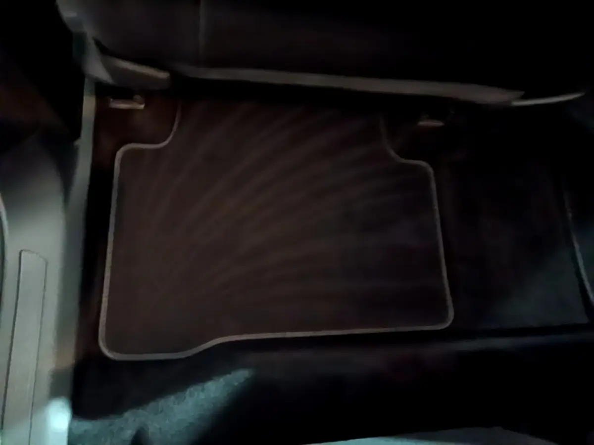 Tapis de sol noir côté passager avant dans l'habitacle du Volkswagen Touran gris foncé 2023.